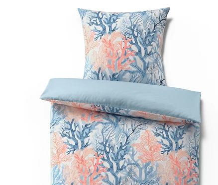 Ensemble de literie avec drap-housse bleu et taie d'oreiller à motif de coraux bleus et corail.