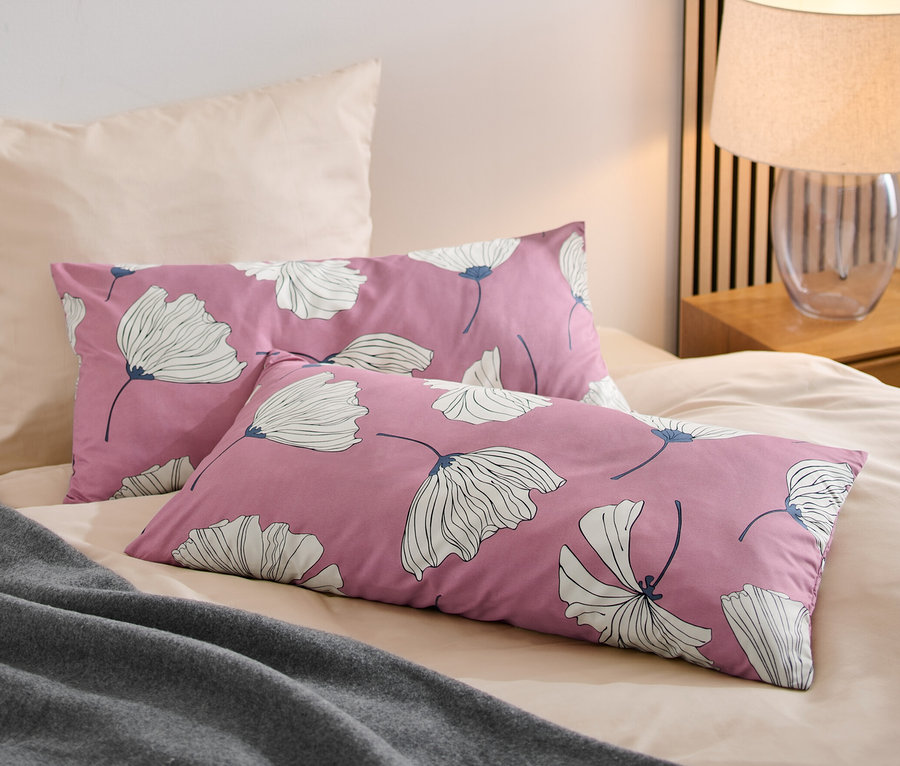 Sur un lit, deux taies d'oreiller en microfibre.