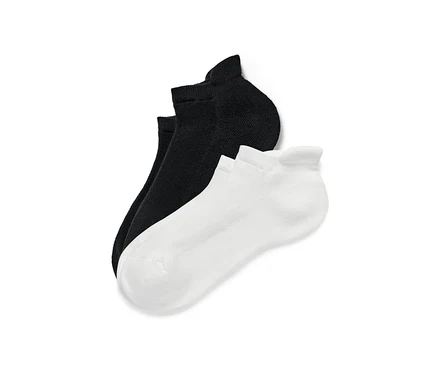 Deux paires de socquettes de sport, une paire noire et une paire blanche.