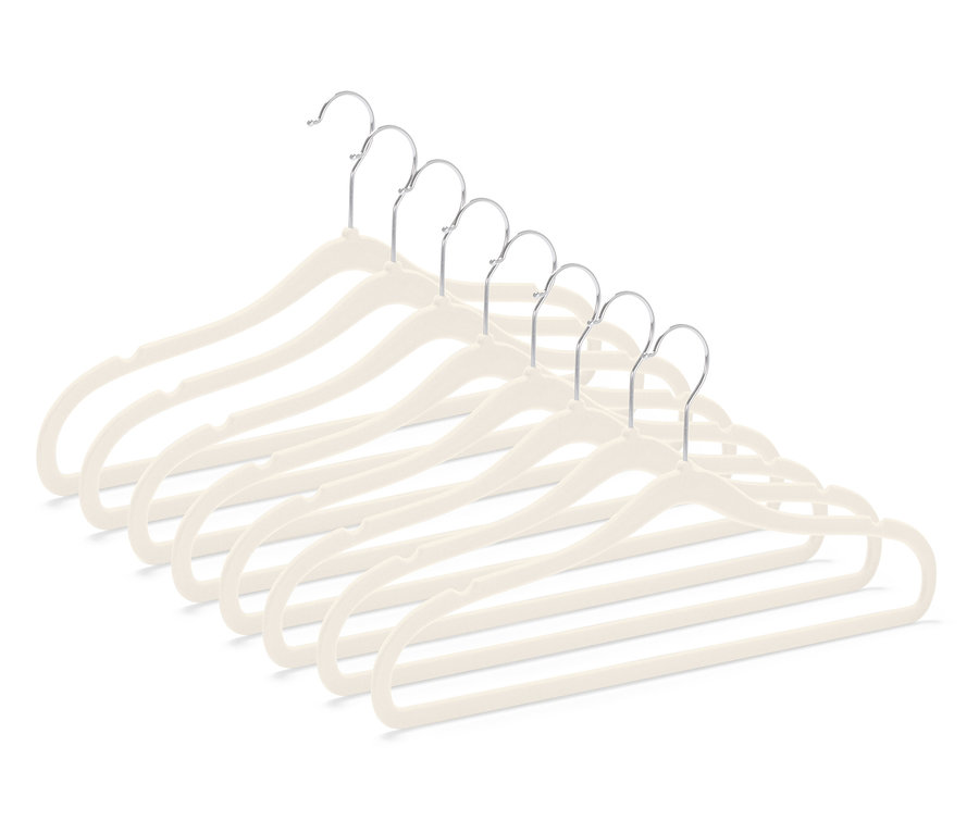 Sept cintres beiges en velours avec crochets chromés, disposés en diagonale dans le coin inférieur droit.