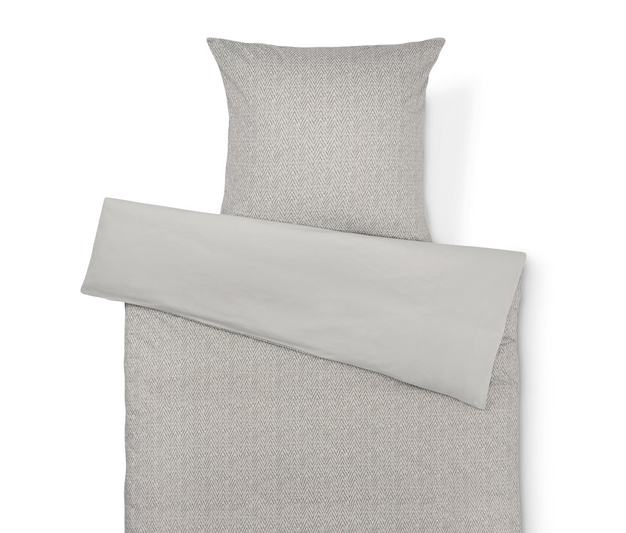 Linge de lit beige avec motif Ă chevrons gris et taie d'oreiller beige unie.