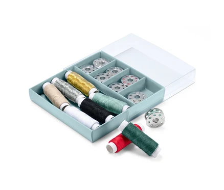 Un kit de fil à coudre dans une boîte bleue avec un couvercle transparent.