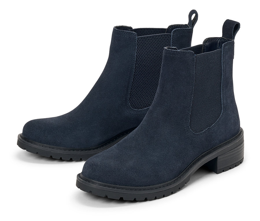 Deux bottes Chelsea en daim bleu marine sur fond blanc.