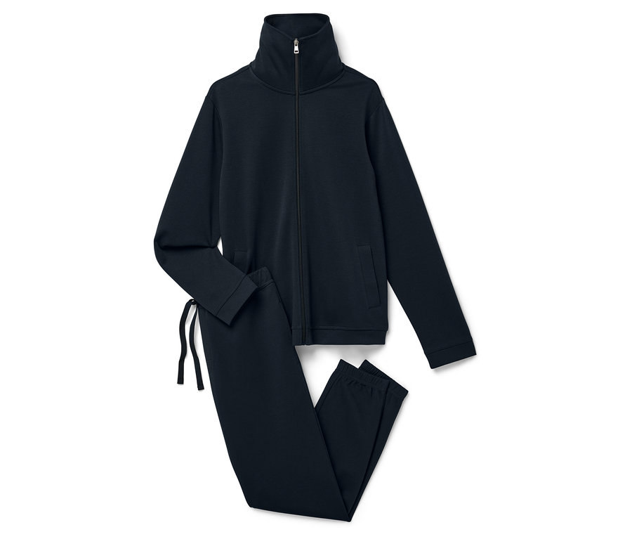 Un survêtement bleu marine composé d'une veste zippée et d'un pantalon posé sur un fond blanc.