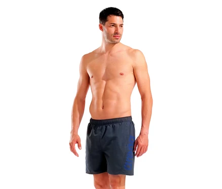 Homme portant un short de bain gris arena Fundamentals Logo R, regardant à droite.