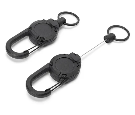 Deux porte-clés rétractables noirs avec mousquetons reposent sur un fond blanc.