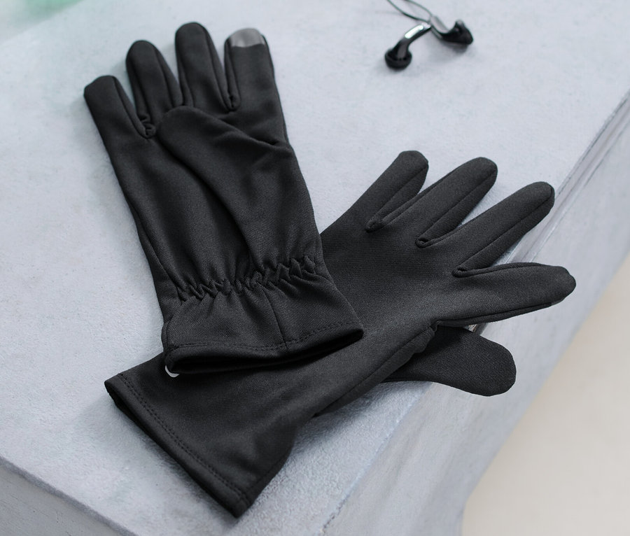 Des gants de course, une bouteille d'eau et des écouteurs sont posés sur un banc.