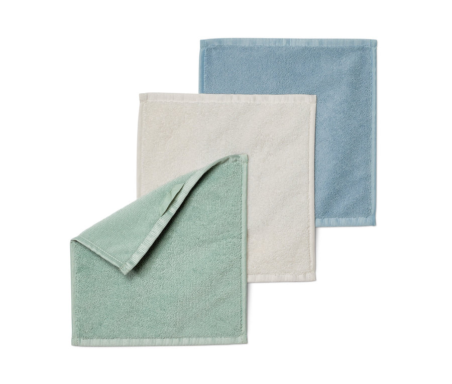 Trois serviettes cosmétiques en microfibre en bleu, crème et vert.