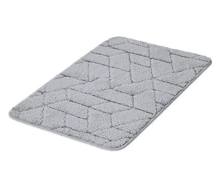 Un tapis gris avec un motif géométrique repose sur un fond blanc.