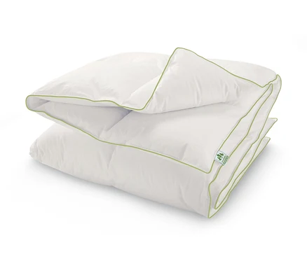 Une couette en duvet à cassettes irisette® greenline blanche pliée avec une bordure verte.