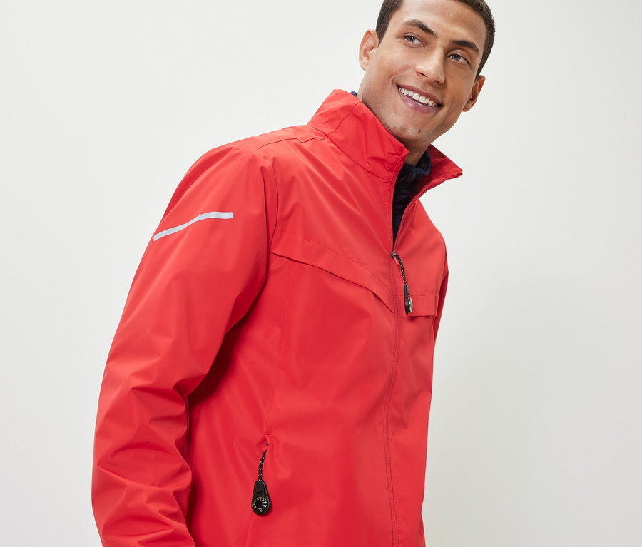 Homme portant une veste rouge avec 2 breloques pour fermetures éclair.