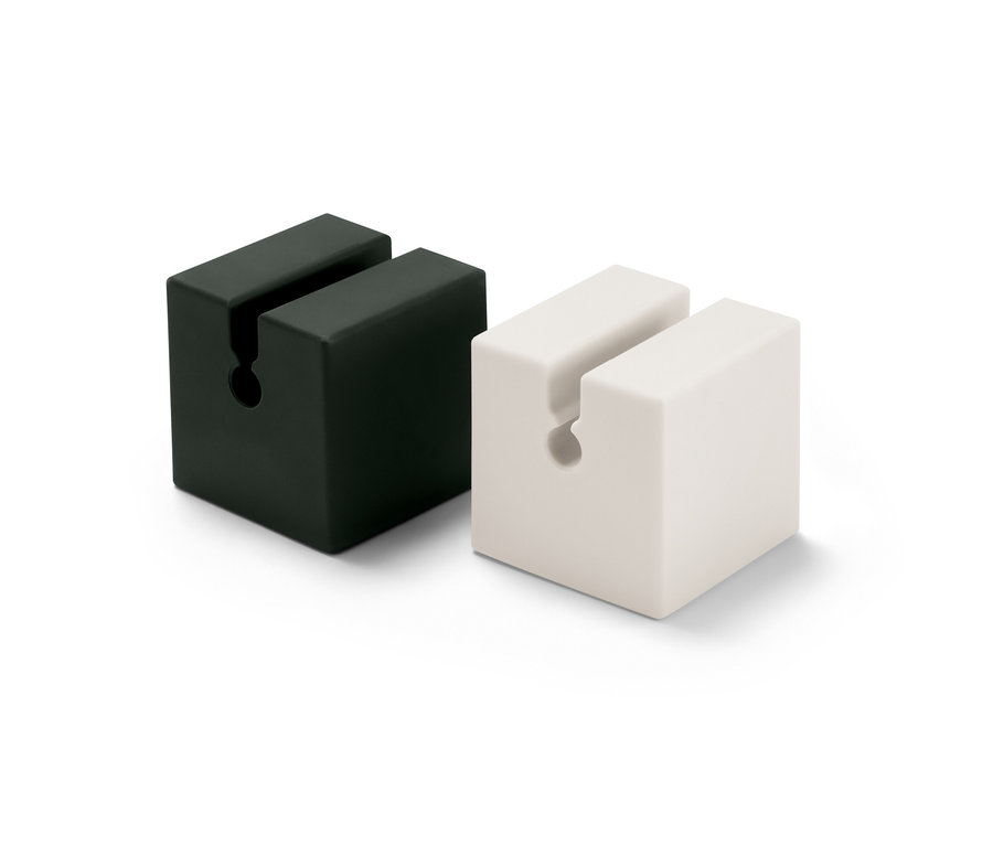 Deux organiseurs de câble de recharge, en 2 parties, un noir et un blanc, se tiennent l'un à côté de l'autre.