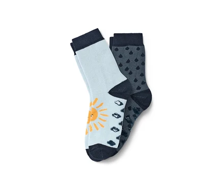Deux paires de chaussettes antidérapantes bleues pour tout-petits. Une paire bleu clair avec un soleil jaune, l'autre bleu foncé avec un motif de pluie.