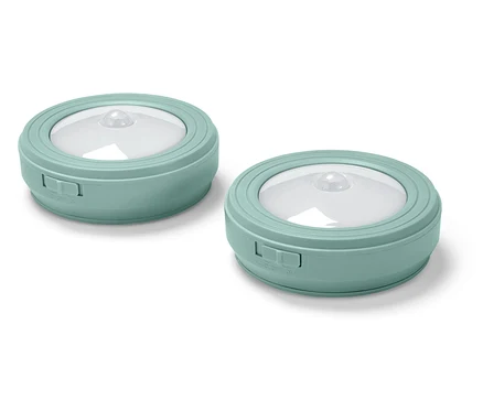 Deux lumières rondes bleu-vert sur fond blanc.