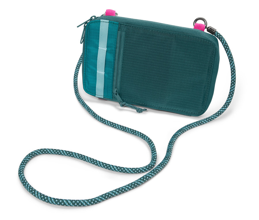 Un sac à bandoulière vert avec une bandoulière en corde bleu-vert repose sur un fond blanc.