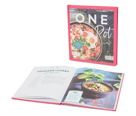Un livre de cuisine intitulé « Simply One Pot » est ouvert sur une page contenant la recette du curry d'edamame au pak choi.