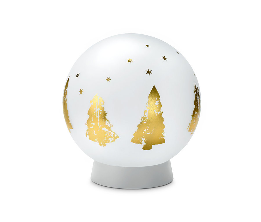 Une lampe solaire à globe en verre décorée de sapins de Noël et d'étoiles dorées.