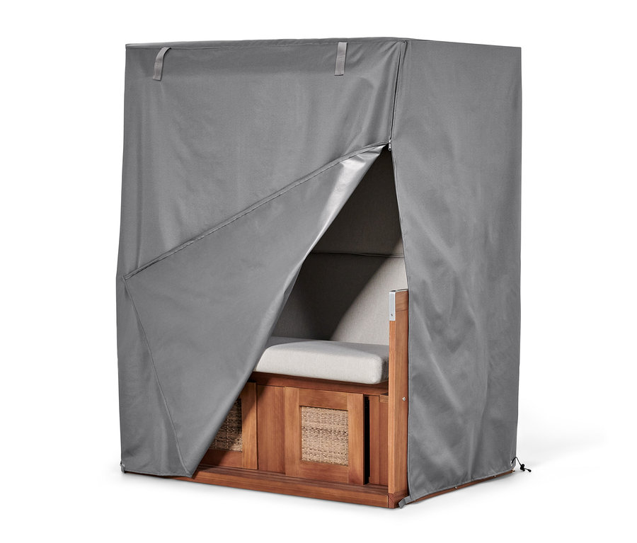 Un fauteuil de plage est recouvert d'une housse premium grise XXL, partiellement ouverte.