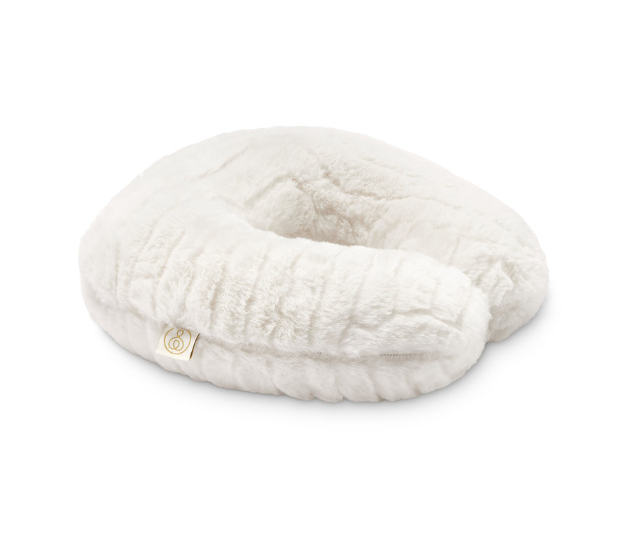 Un coussin de nuque blanc en mousse à mémoire de forme sur fond blanc.