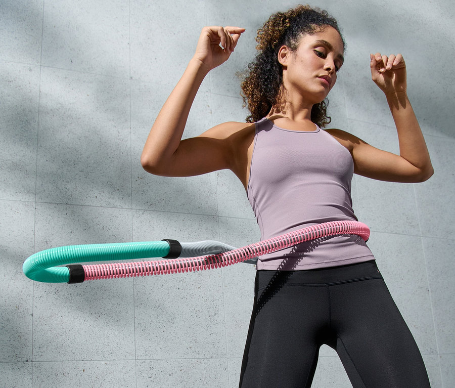 Femme faisant de l'exercice avec un cerceau de fitness flexible.