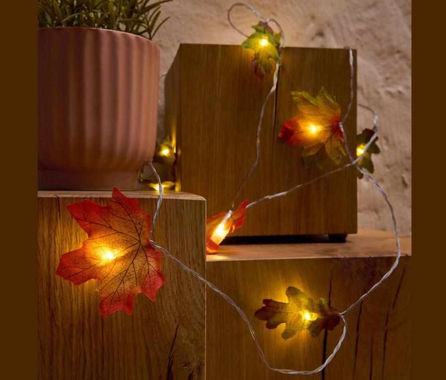 Guirlande lumineuse à LED « Feuilles » enroulée autour de blocs de bois et d'une plante en pot.