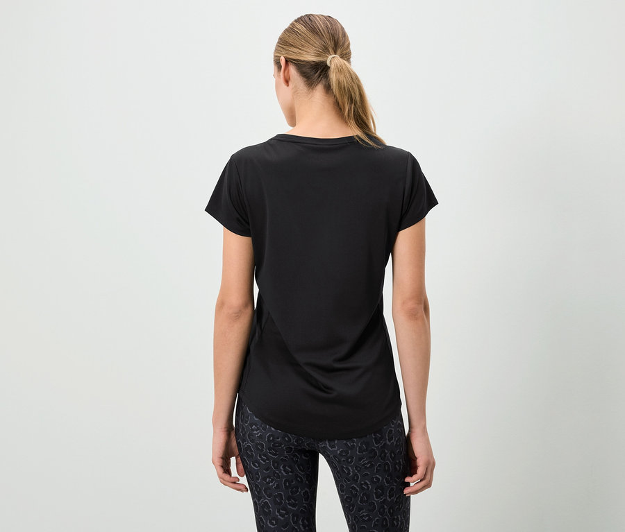Femme vue de dos portant un t-shirt noir et un legging à motifs.