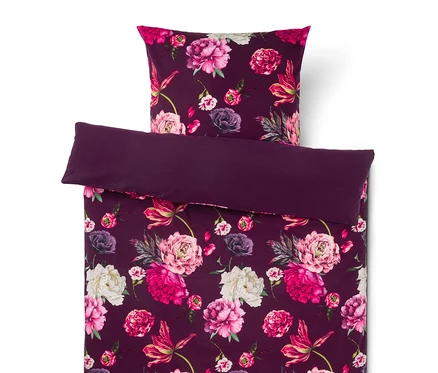 Parure de lit violet foncé à motif floral, comprenant un oreiller et une housse de couette pliée avec des pivoines roses, fuchsia et blanches.