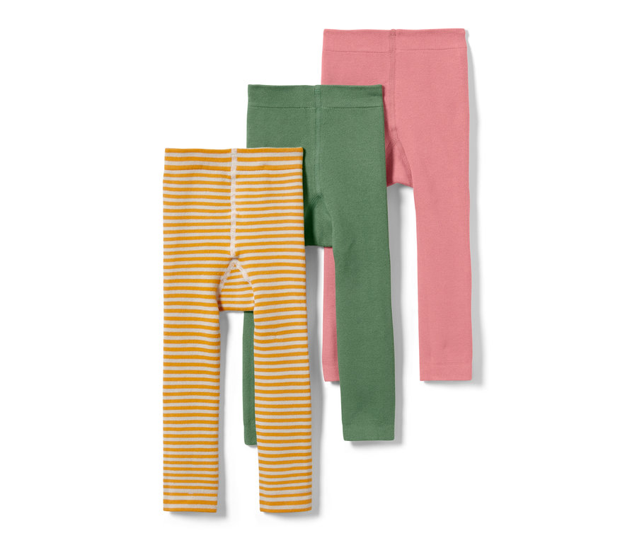 Trois leggings thermiques pour enfant : un rayé orange et blanc, un vert et un rose.
