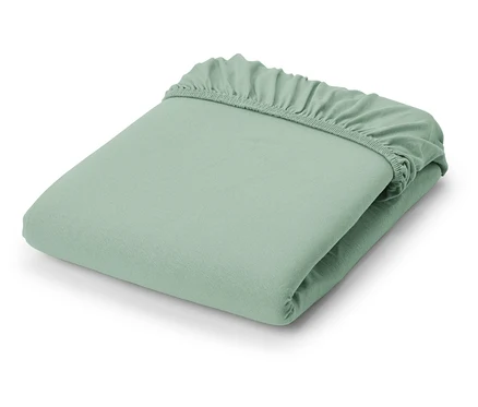 Un drap-housse en jersey vert clair plié.