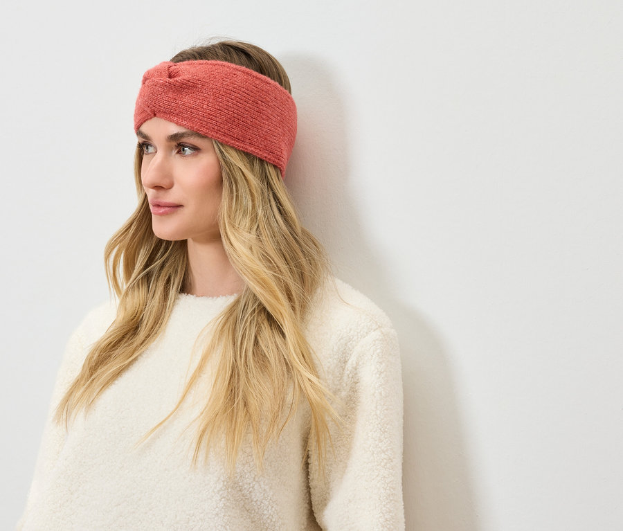 Femme blonde portant un bandeau corail.