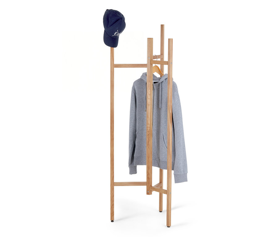 Une casquette de baseball bleue repose sur un porte-manteau en bois, sur lequel est suspendu un sweat à capuche gris zippé.