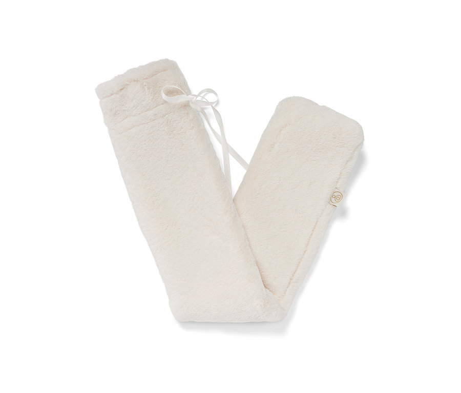 Une bouillotte tube couleur crème avec une couverture en peluche et un ruban blanc.