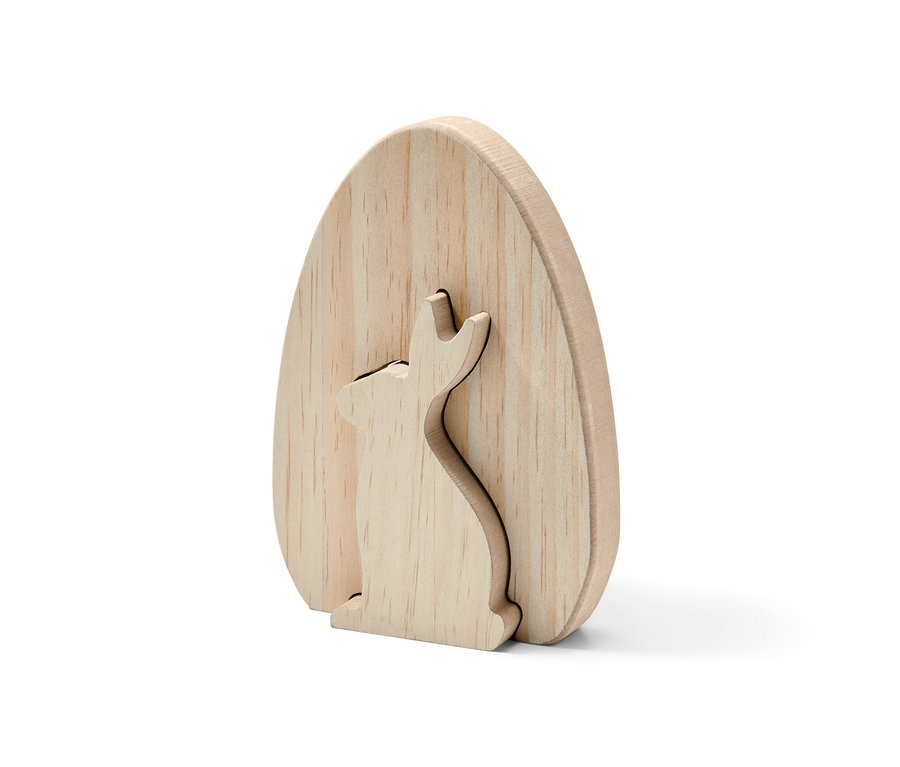 Un lapin décoratif en bois non peint en forme d'œuf, dans lequel est découpé un lapin.