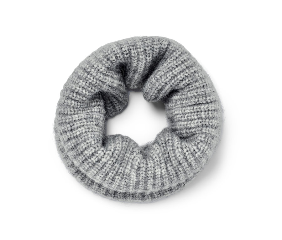 Une écharpe tube tricotée grise est posée sur le sol.