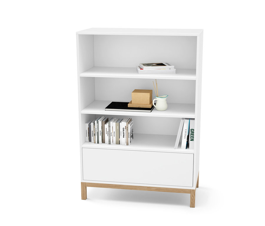 Commode blanche avec tiroir et étagères contenant des livres et des décorations.