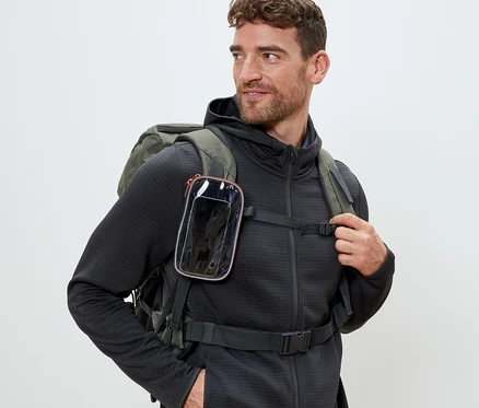 Un homme portant un sac à dos avec une pochette multifonction avec fenêtre transparente attachée à la sangle.