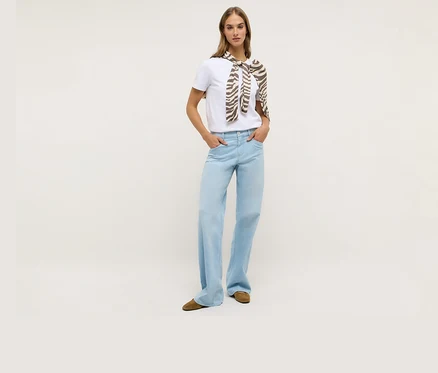Femme portant un t-shirt blanc et un jean Angels Denim « Liz Modern » à jambes larges. Un foulard à motif zébré est noué autour de ses épaules.