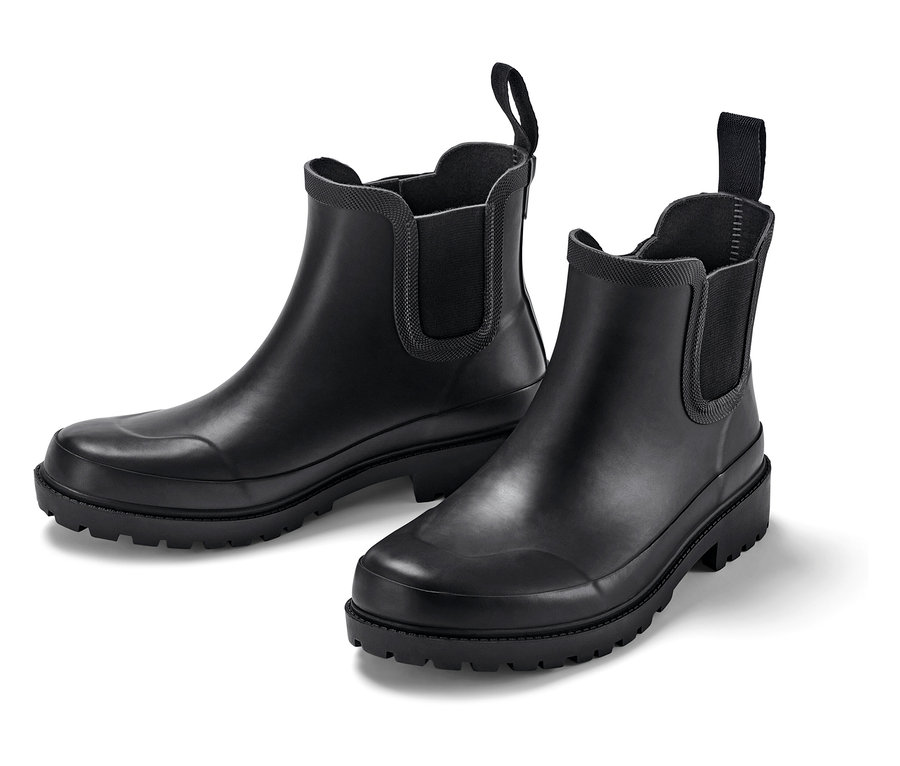 Deux bottes en caoutchouc noires sur fond blanc.