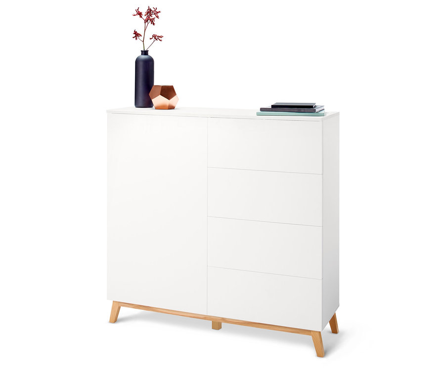 Commode blanche avec quatre tiroirs et des fleurs dans un vase sur le dessus.