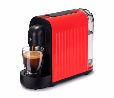 L'espresso coule dans un verre sous une Cafissimo now rouge.