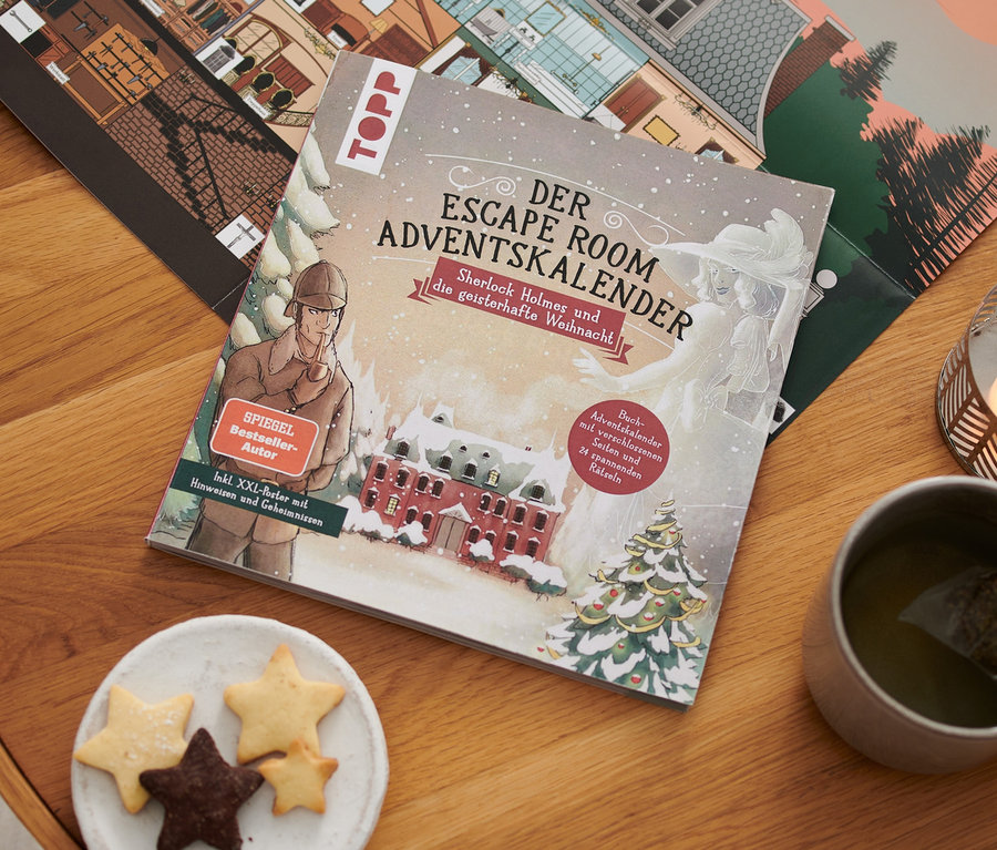 Sur une table en bois sont posés le livre de calendrier de l'avent Escape « Sherlock Holmes und die geisterhafte Weihnacht », une bougie, une tasse de thé et une assiette de biscuits.