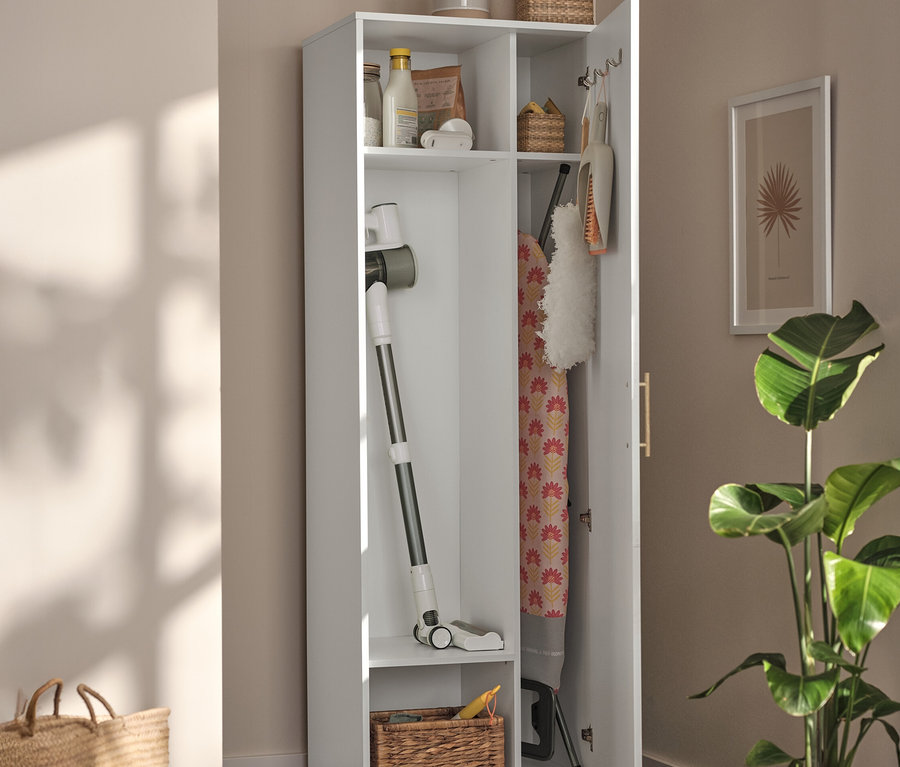 Armoire universelle blanche ouverte avec aspirateur, planche à repasser et paniers à l'intérieur.