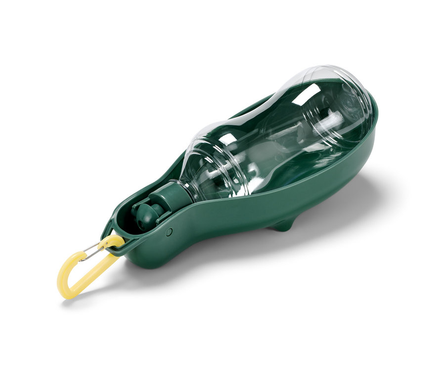 Une gourde transparente pour chien avec gamelle verte intégrée.