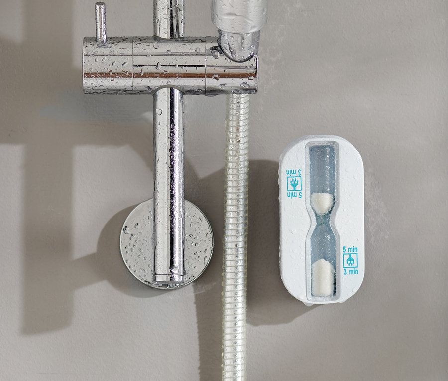 Un sablier de douche fixé au mur à côté d'une pomme de douche.