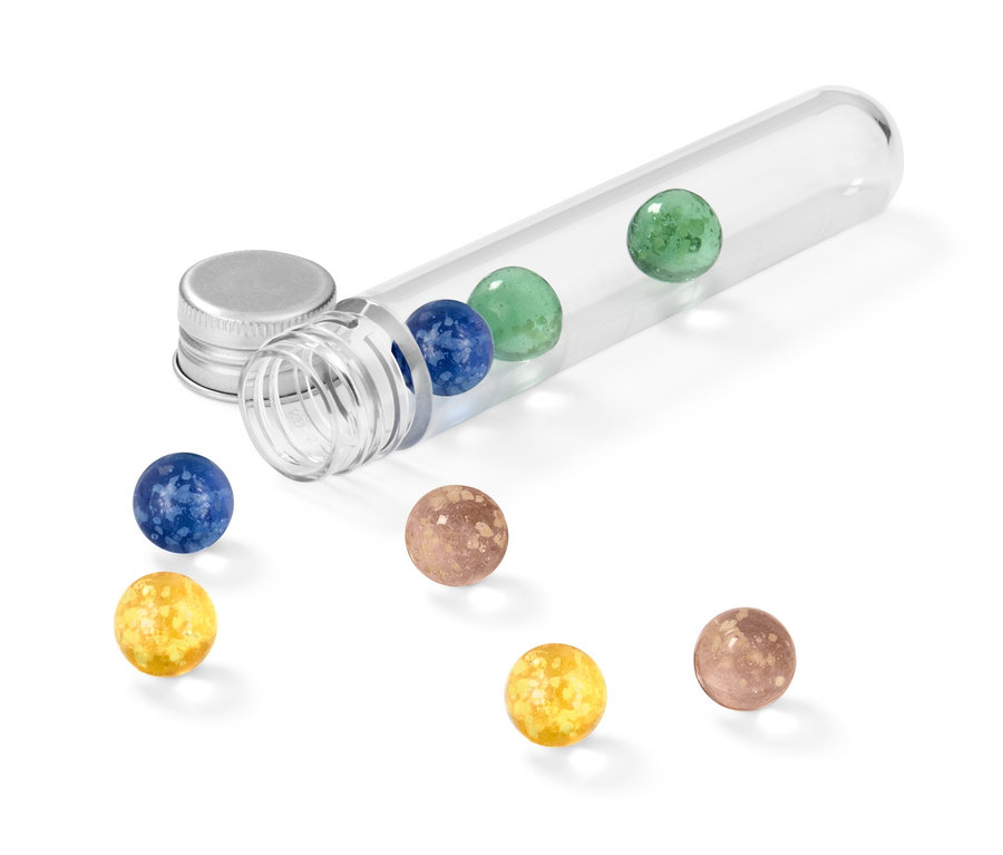 Un tube à essai transparent est posé sur le côté et contient des billes lumineuses de différentes couleurs, d'autres billes sont éparpillées à côté.