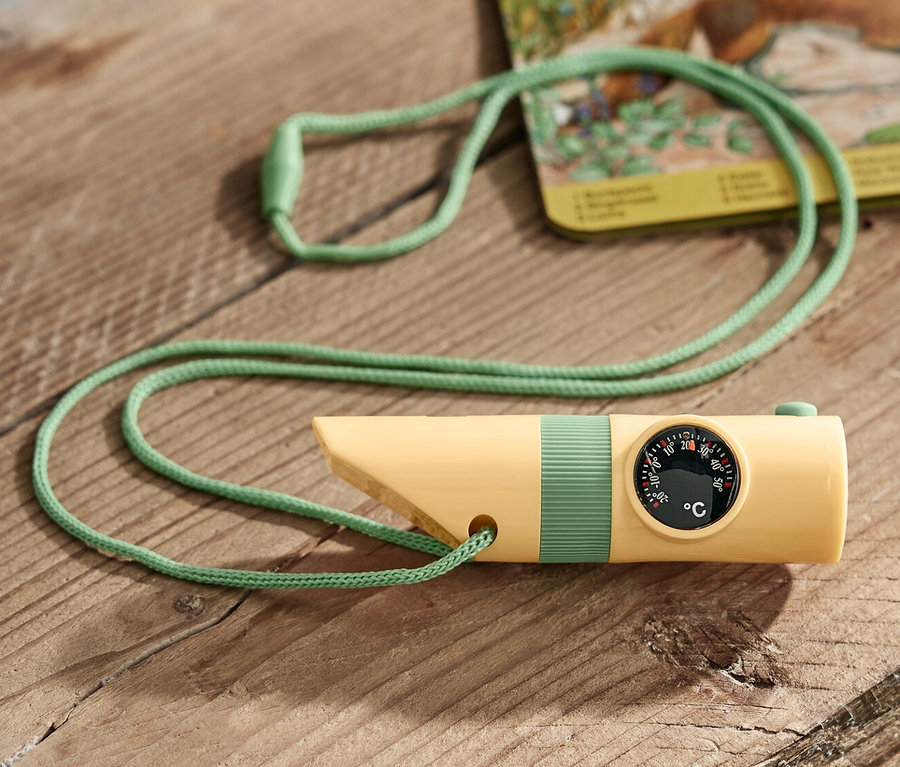 Un outil compact jaune pour l'extérieur avec un cordon vert posé sur une table en bois.