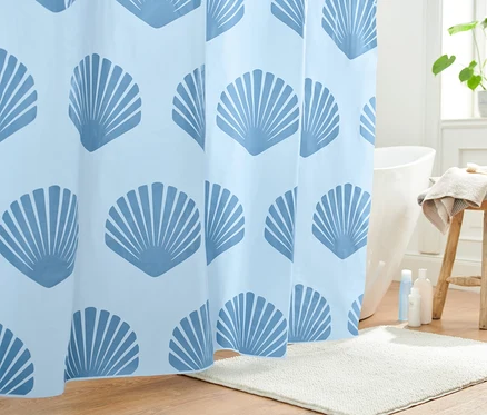 Rideau de douche bleu avec motif de coquillages dans une salle de bain.