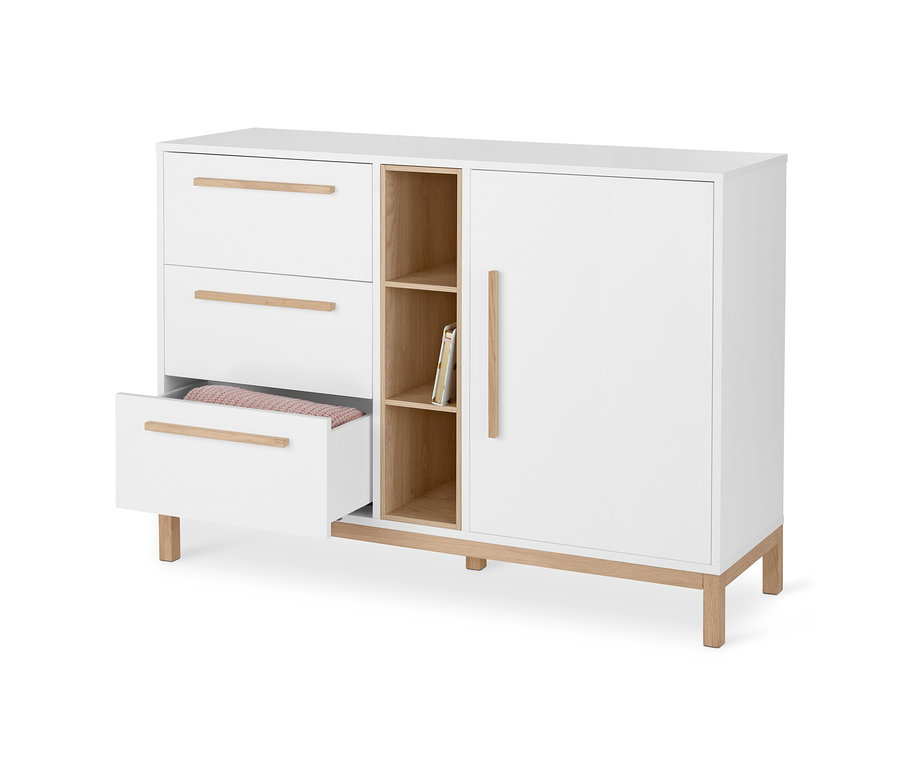 Une commode blanche « Eklund » avec tiroirs et porte, dont un tiroir est ouvert et contient des vêtements.