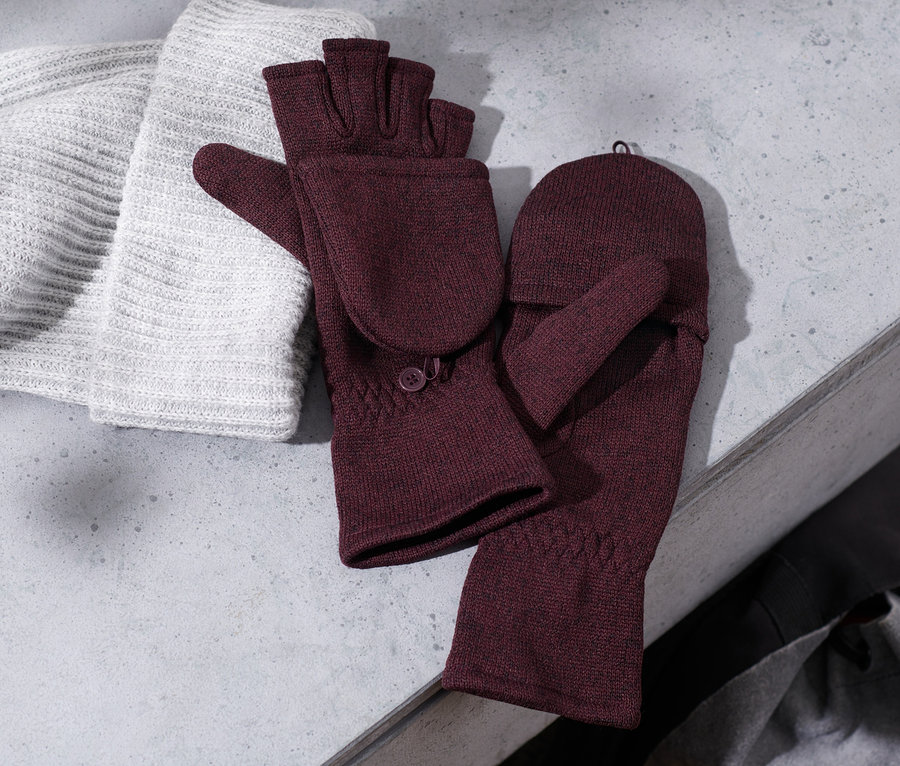 Un bonnet en tricot repose à côté de moufles convertibles en maille polaire bordeaux.