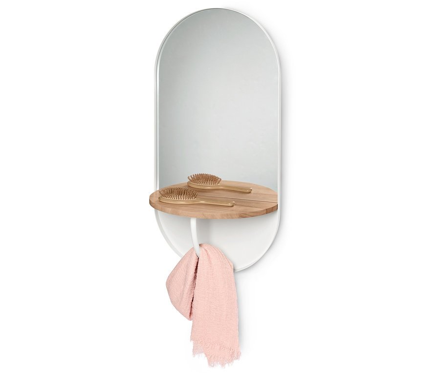 Miroir ovale avec cadre blanc et étagère en bois, sur laquelle reposent deux brosses à cheveux en bois. Une serviette rose est suspendue en dessous.